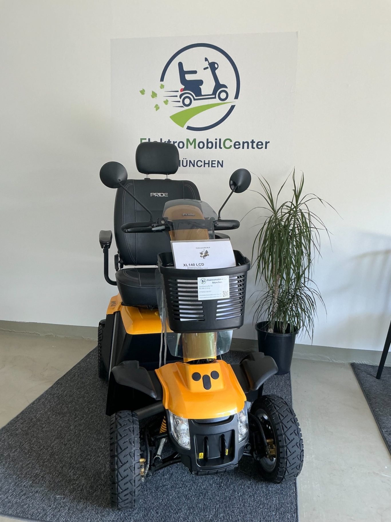 Elektromobil in Gelb, platziert vor einem Logo mit Mobilitätsdienstleistungen.